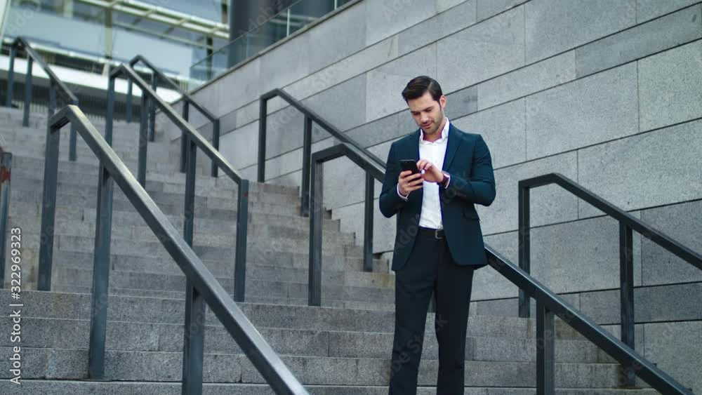 Man using phone at modern street. Businessman checking time on twatch outside Man using phone at modern street. Businessman checking time on twatch outside