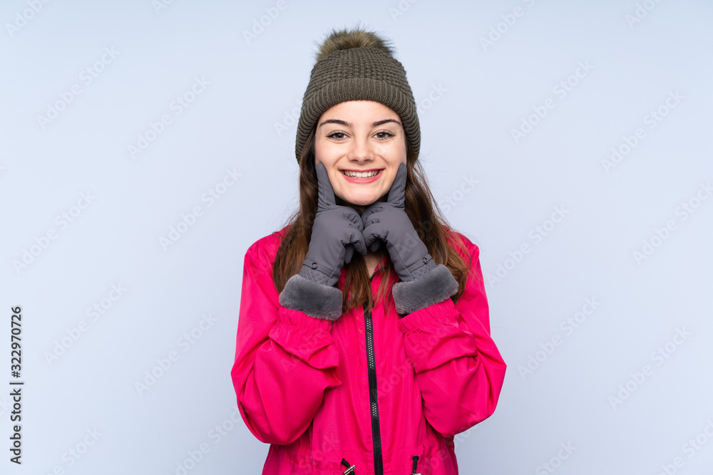 Young girl with winter hat isolated on blue background smiling with a happy and pleasant expression Young girl with winter hat isolated on blue background smiling with a happy and pleasant expression