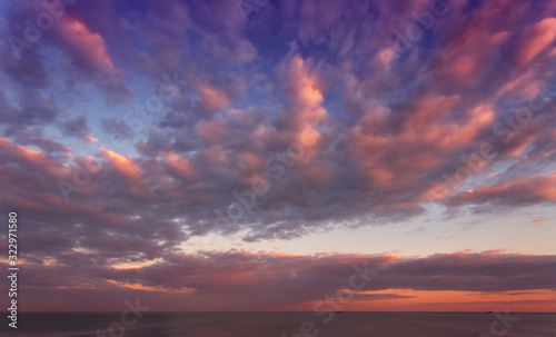 Beautiful sunrise, sunset at sea. Red, gray, pink, yellow clouds. The dark blue sky, the sea.