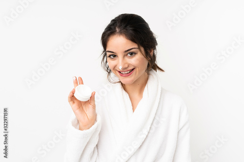 Young caucasian woman isolated on white background with moisturizer and happiness