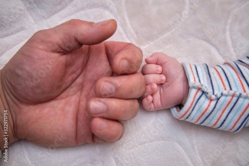 The man's hand and baby's hand.