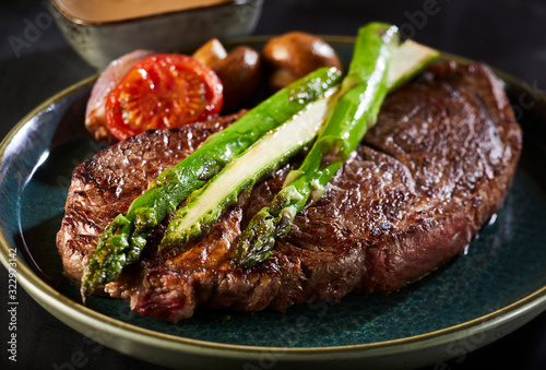 Photography Thick juicy beef steak with green asparagus