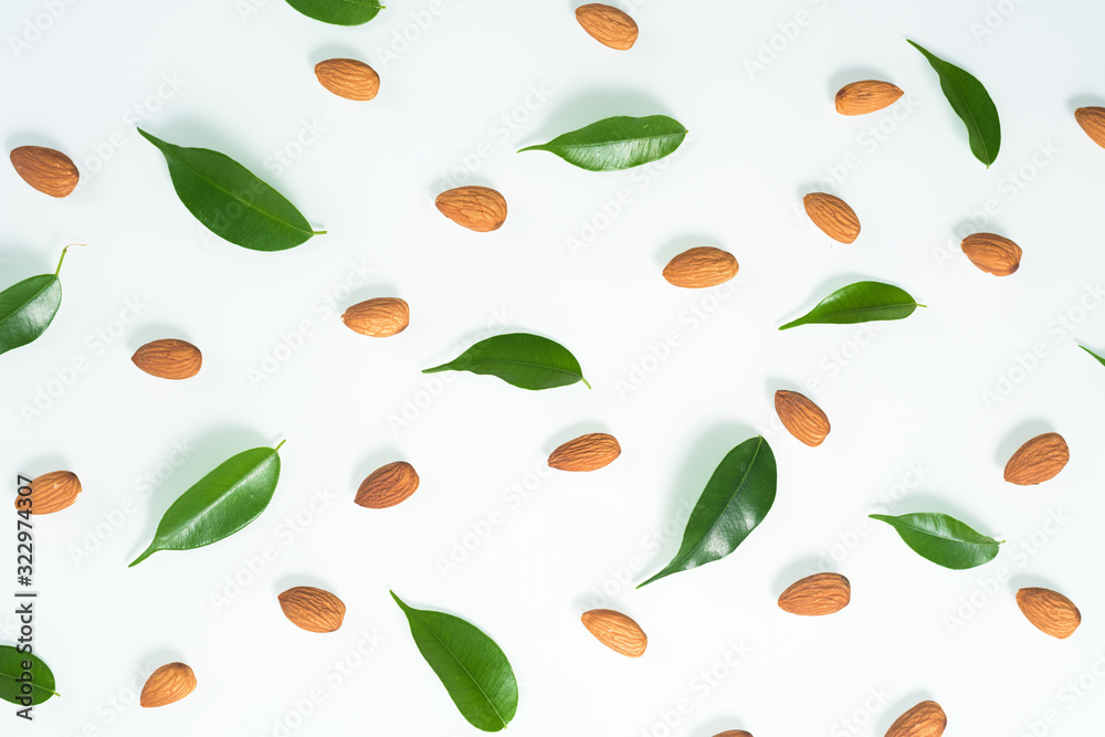 almonds and green leaves isolated on a white background. spring composition, top view. nutritious nut, healthy nutrition. almonds and green leaves isolated on a white background. spring composition, top view. nutritious nut, healthy nutrition.