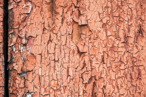 Cracked brown paint close-up. Background from a ragged wall in terracotta color.