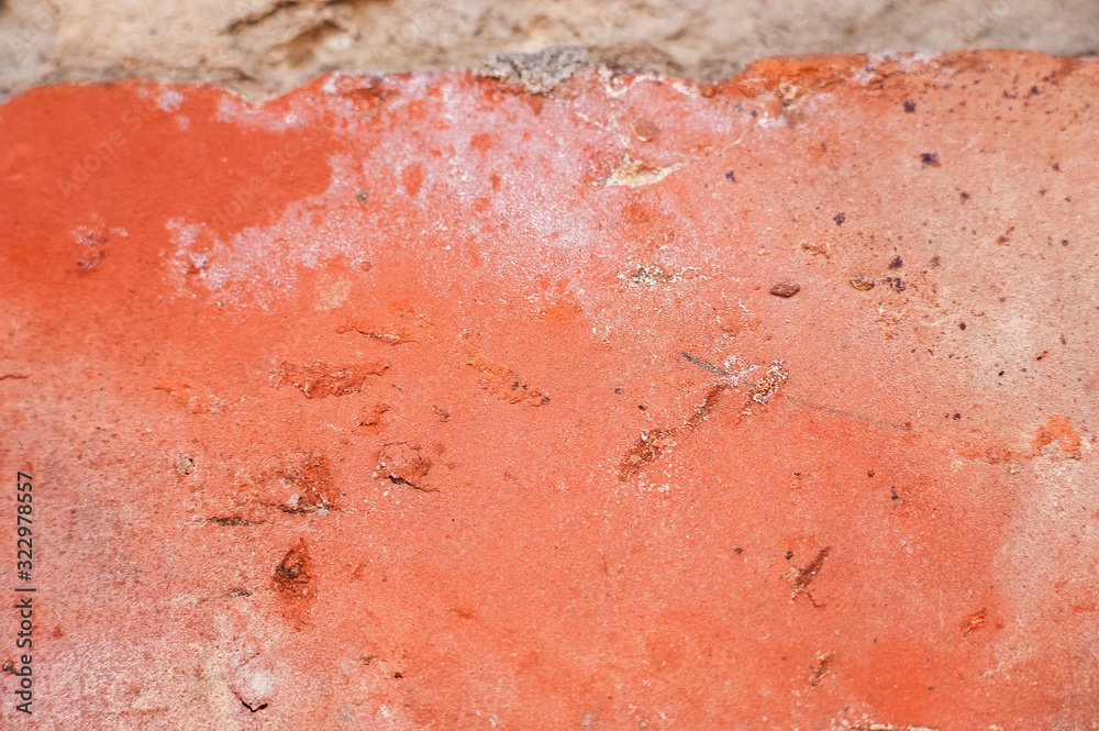 Fototapeta premium Cracked brown paint close-up. Background from a ragged wall in terracotta color.