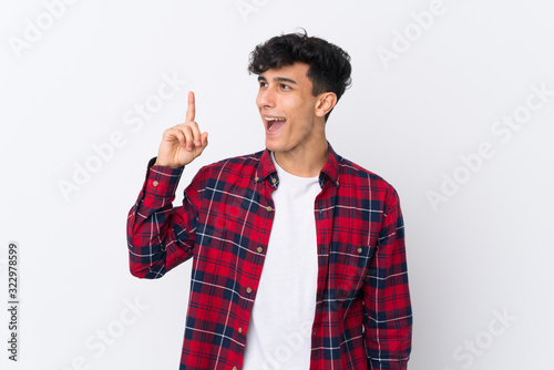 Young Argentinian man over isolated white background intending to realizes the solution while lifting a finger up