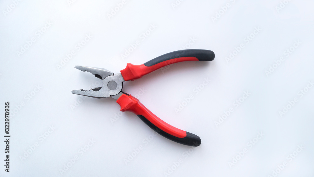 Steel pliers with a red-black handle are in the open state on a white background. Repair tool. Steel pliers with a red-black handle are in the open state on a white background. Repair tool.