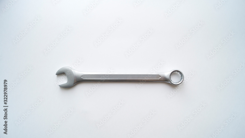 One steel combination wrench lies on a white background. Repair tool. One steel combination wrench lies on a white background. Repair tool.