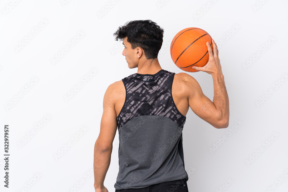 Young Argentinian man over isolated white background playing basketball in back position