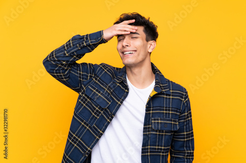 Young Argentinian man over isolated yellow background laughing