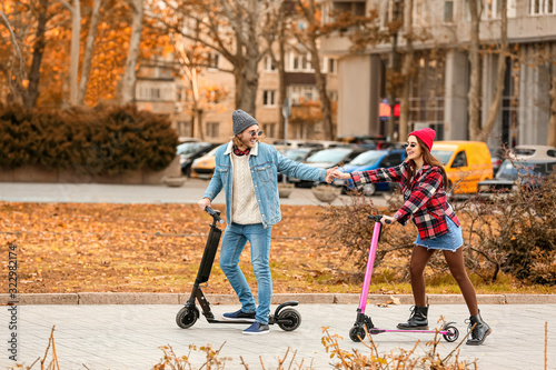 Young couple riding kick sc...