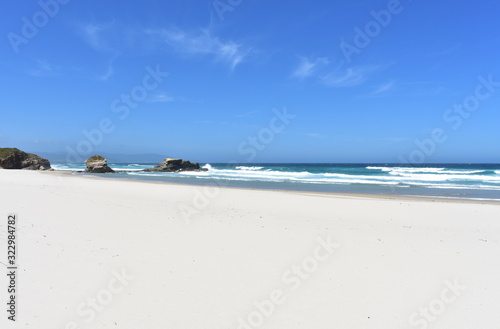 Summer landscape with white sand beach and wild sea with waves breaking. Viveiro, Lugo, Galicia, Spain. photo