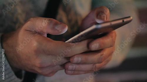 Hands of a man with a smartphone in the evening at a party. Close up. Flashing light, event, incident, disco. Close up.