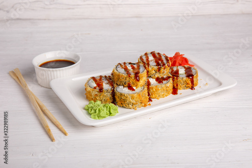 Deep-fried Japanese roll with tiriaki sauce. Traditional Japanese cuisine, menu on a white background