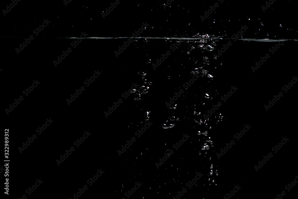 something falls into the water and causes seething and air bubbles on a black background for installation