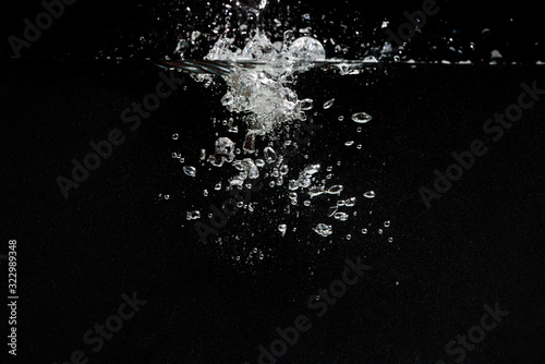 something falls into the water and causes seething and air bubbles on a black background for installation