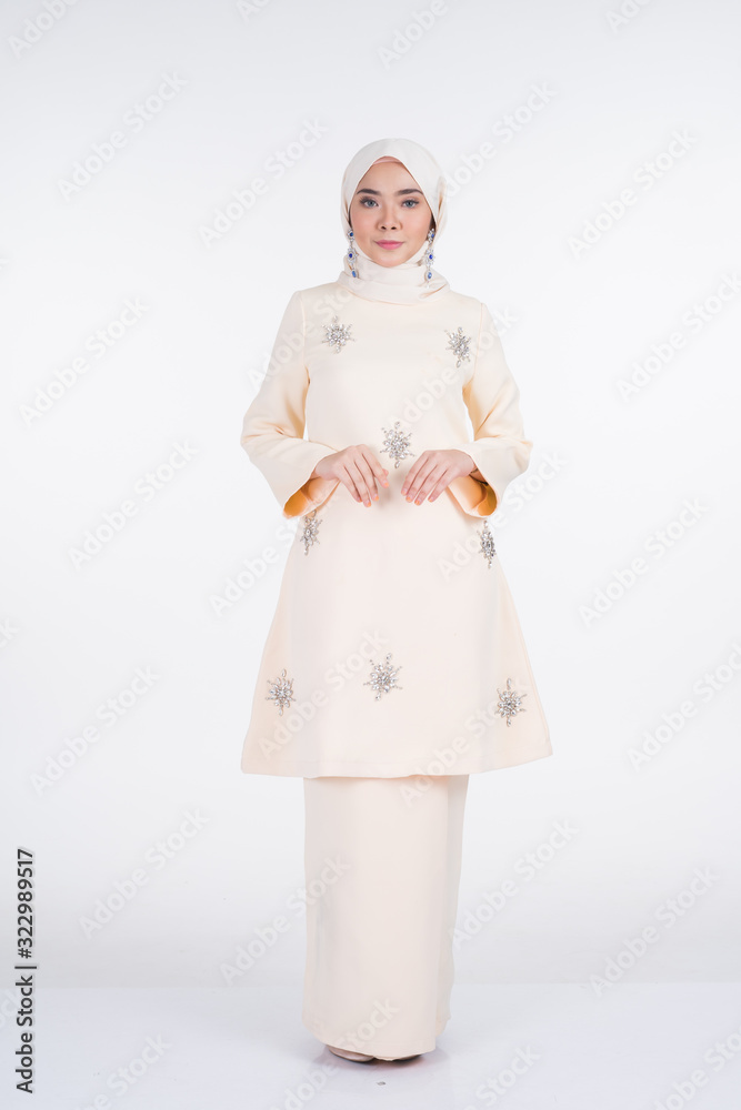 Beautiful female Muslim model in various poses wearing kurung Pahang and hijab, a lifestyle apparel for Muslim women isolated on white. Beauty and hijab fashion concept. Full length portrait Beautiful female Muslim model in various poses wearing kurung Pahang and hijab, a lifestyle apparel for Muslim women isolated on white. Beauty and hijab fashion concept. Full length portrait