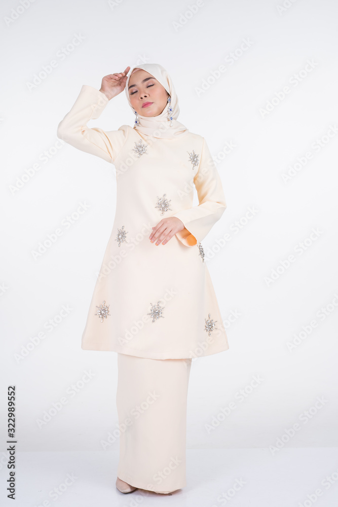 Beautiful female Muslim model in various poses wearing kurung Pahang and hijab, a lifestyle apparel for Muslim women isolated on white. Beauty and hijab fashion concept. Full length portrait Beautiful female Muslim model in various poses wearing kurung Pahang and hijab, a lifestyle apparel for Muslim women isolated on white. Beauty and hijab fashion concept. Full length portrait