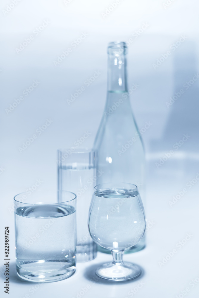 Transparent glass set with a bottle, isolated on a white background. Three glasses of water. Transparent glass set with a bottle, isolated on a white background. Three glasses of water.