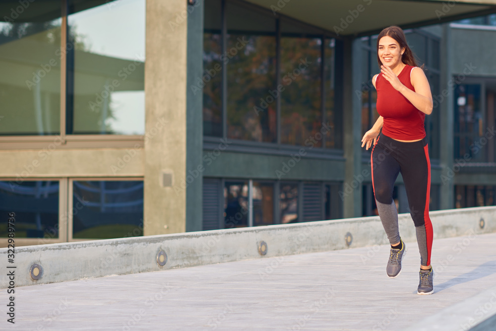 Young woman exercising / running in urban park.