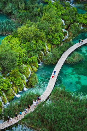 Tourists walk by wooden path, in the Plitvice Lakes National Park  which is a UNESCO World Heritage site.
