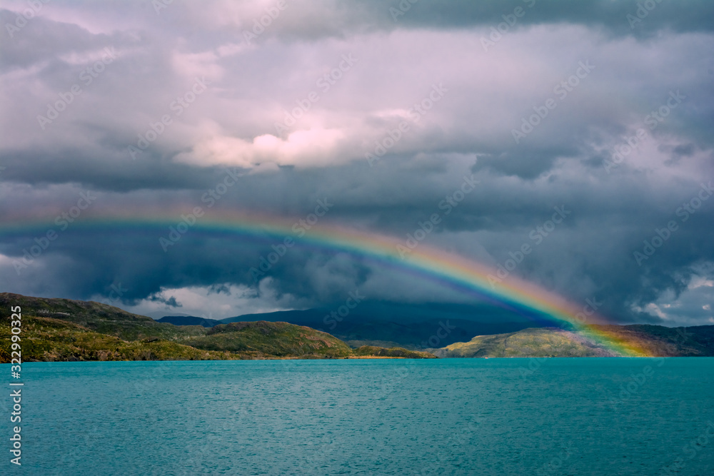 Rainbow over turquoise water of Pehoe Lake in Torres Del Paine, Patagonia, Andes, Chile.
