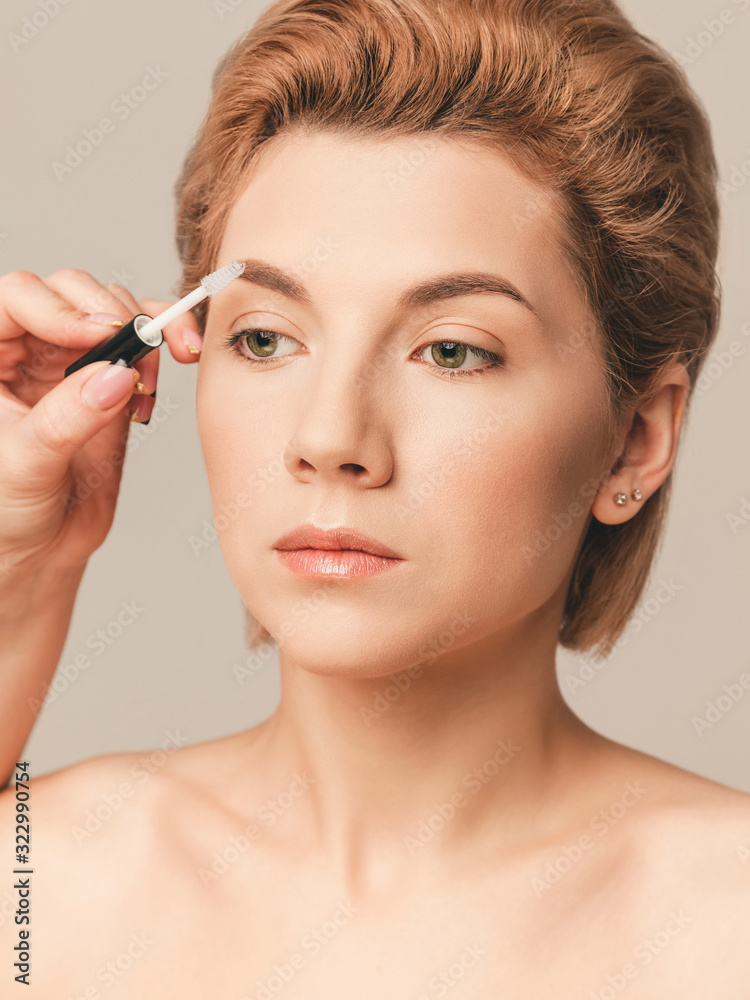 Fototapeta premium everyday classic makeup in nude color - styling eyebrows with gel. Close-up shot in studio