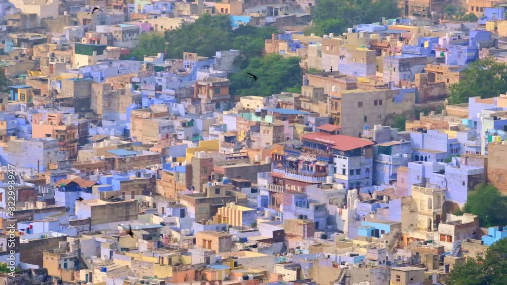 Jodhpur the Blue City aerial view. Blue painted houses and birds flying in the morning above brahmin houses, view from Mehrangarh Fort, Rajasthan, India. Camera horizontal pan Jodhpur the Blue City aerial view. Blue painted houses and birds flying in the morning above brahmin houses, view from Mehrangarh Fort, Rajasthan, India. Camera horizontal pan