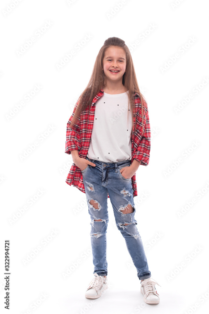 Full length portrait of a young smiling girl stands with her hands in her pockets against a white background. Full length portrait of a young smiling girl stands with her hands in her pockets against a white background.
