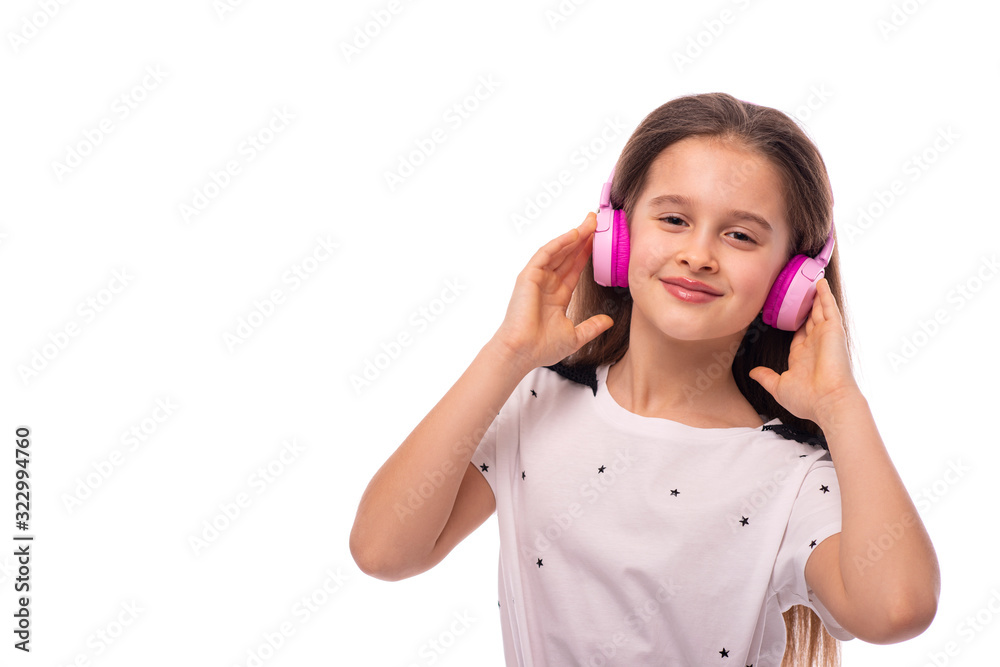 Half length portrait of a young smiling girl listening to music in pink headphones, isolated Half length portrait of a young smiling girl listening to music in pink headphones, isolated