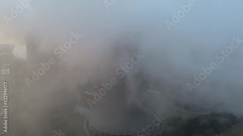 Aerial dolly left view of atmospheric  power station cooling towers smoke steam emissions global warming.