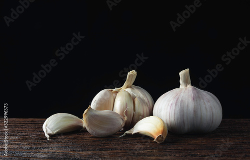 Fresh white garlic on wooden table with black background. Food and healthy concept.