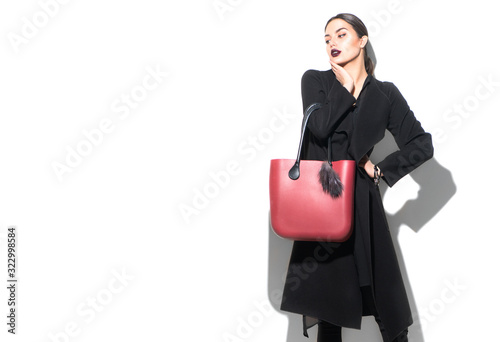 Fashion Model girl portrait, isolated on white background. Beauty look. Stylish brunette woman posing in fashionable clothes in studio. Spring fashion, black coat, trendy bag, Casual style