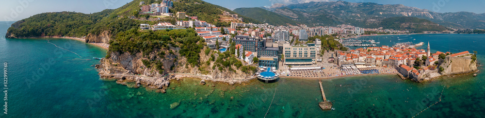 Aerial view of Mogren beach (two sandy beaches) and the old city (stari grad) of Budva. Montenegro. Jagged coast on the Adriatic Sea - obrazy, fototapety, plakaty 