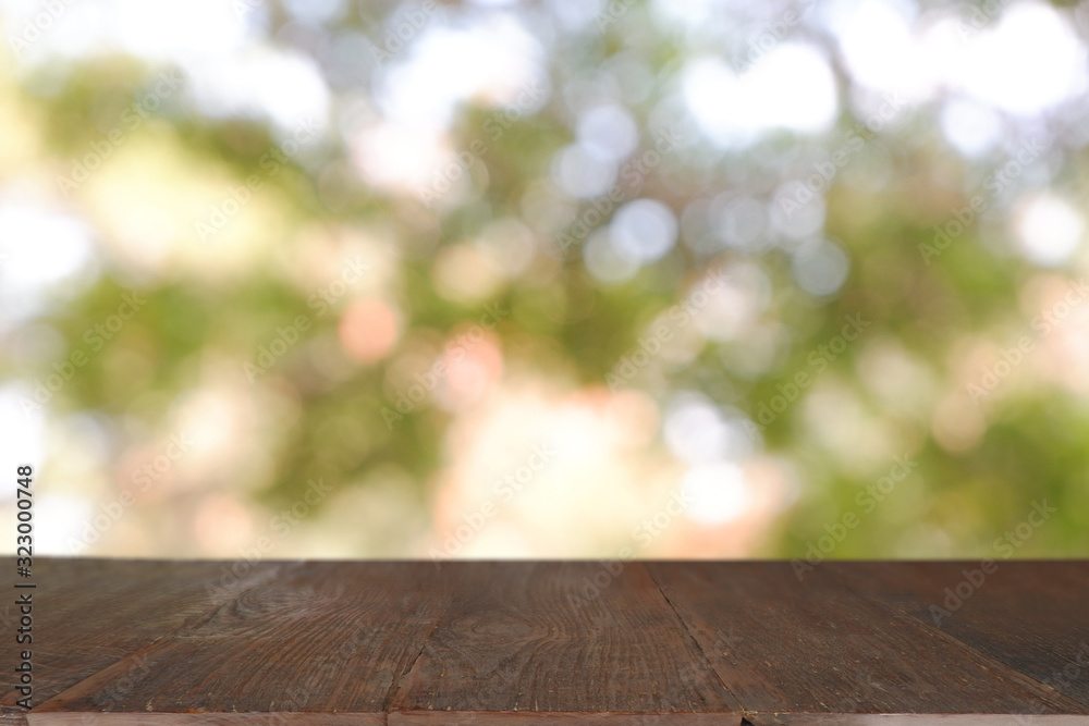 Empty wooden table in front of abstract blurred green bokeh light of garden and nature light background. For montage product display or design key visual layout - Image