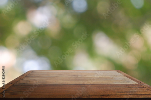 Empty wooden table in front of abstract blurred green bokeh light of garden and nature light background. For montage product display or design key visual layout - Image