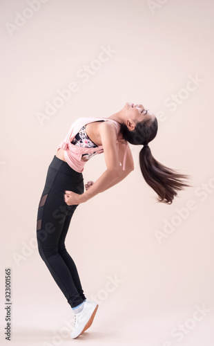 Young lady wearing exercise set outstretch her legs,bend body ,point toe down,flicking hair,,show basic of dance workout,with happy feeling