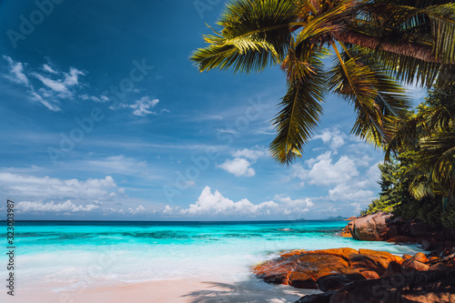Exotic tropical beach. Pristine crystal clear turquoise ocean water with blue sky and white clouds. Summer recreation vacation lifestyle concept