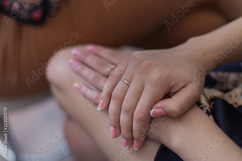 Tender hands of a young girl in a home coat.