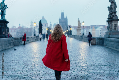Photography Female tourist walking alone on the Charles Bridge during the early morning in P