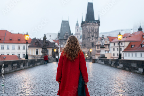 Photography Female tourist walking alone on the Charles Bridge during the early morning in P