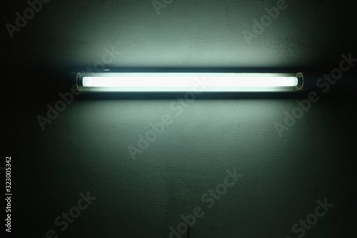 White old fluorescent lamp on cement wall