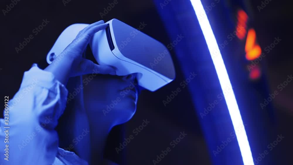 Young cute girl watching 360 video or playing VR video game, using future technology getting unforgettable experience. Testing new working or business tools and capabilities
