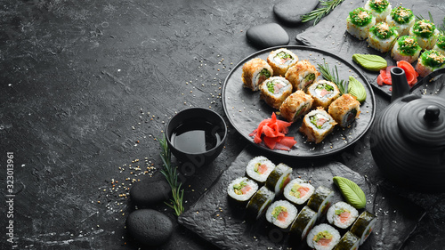 Set of traditional sushi on a black plate. Sushi and rolls on a dark background.