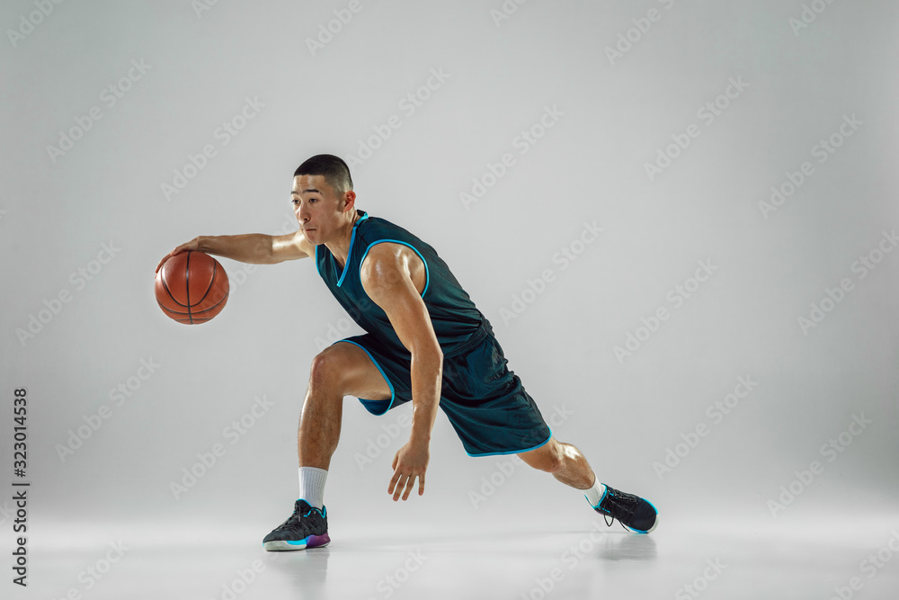 Young basketball player of team wearing sportwear training, practicing in action, motion in run isolated on white background. Concept of sport, movement, energy and dynamic, healthy lifestyle. Young basketball player of team wearing sportwear training, practicing in action, motion in run isolated on white background. Concept of sport, movement, energy and dynamic, healthy lifestyle.