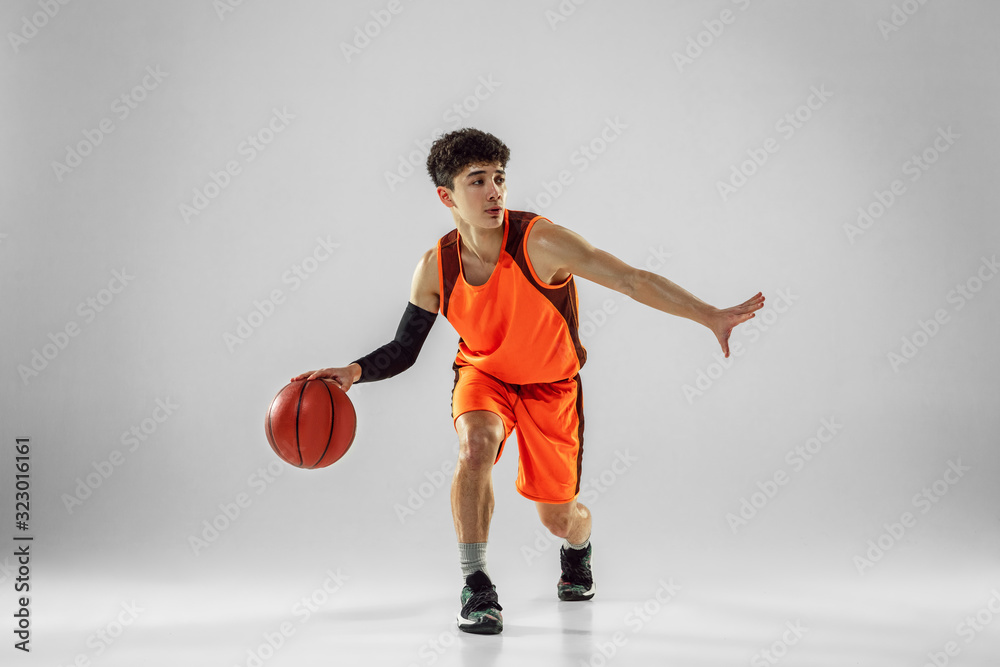 Young basketball player of team wearing sportwear training, practicing in action, motion in run isolated on white background. Concept of sport, movement, energy and dynamic, healthy lifestyle. Young basketball player of team wearing sportwear training, practicing in action, motion in run isolated on white background. Concept of sport, movement, energy and dynamic, healthy lifestyle.