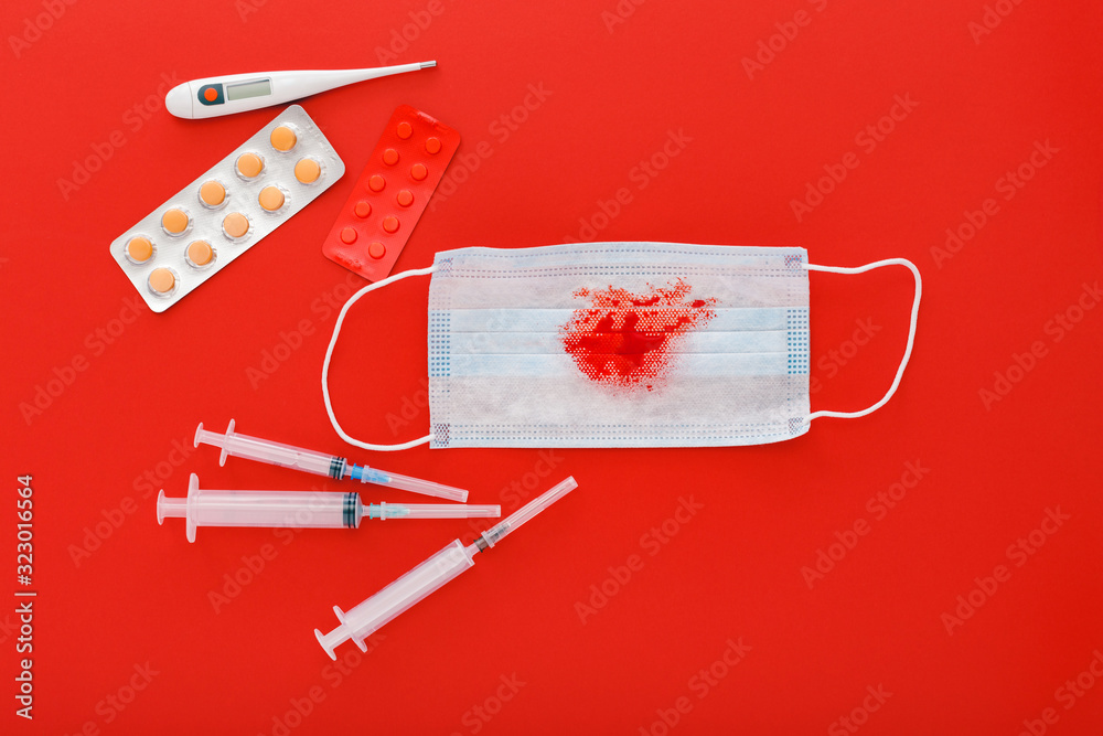Hemoptysis coronavirus, protective surgical mask with blood pills syringes thermometer on red background. Pneumonia, acute respiratory infections, tuberculosis, lung cancer, hemoptysis, epidemic. Hemoptysis coronavirus, protective surgical mask with blood pills syringes thermometer on red background. Pneumonia, acute respiratory infections, tuberculosis, lung cancer, hemoptysis, epidemic.