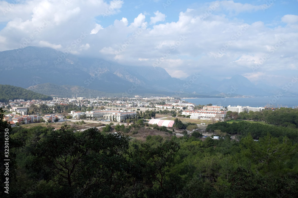 View from observing place point to valley with Kemer city in Antalya region surrounded by high mountains and calm blue Mediterranean sea on bright sunny day