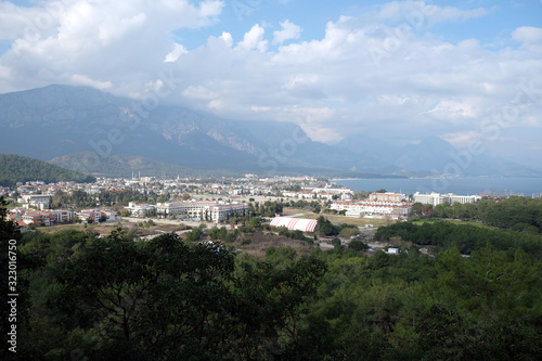 View from observing place point to valley with Kemer city in Antalya region surrounded by high mountains and calm blue Mediterranean sea on bright sunny day