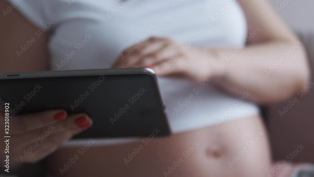 Pregnant woman using a digital tablet Pregnant woman using a digital tablet